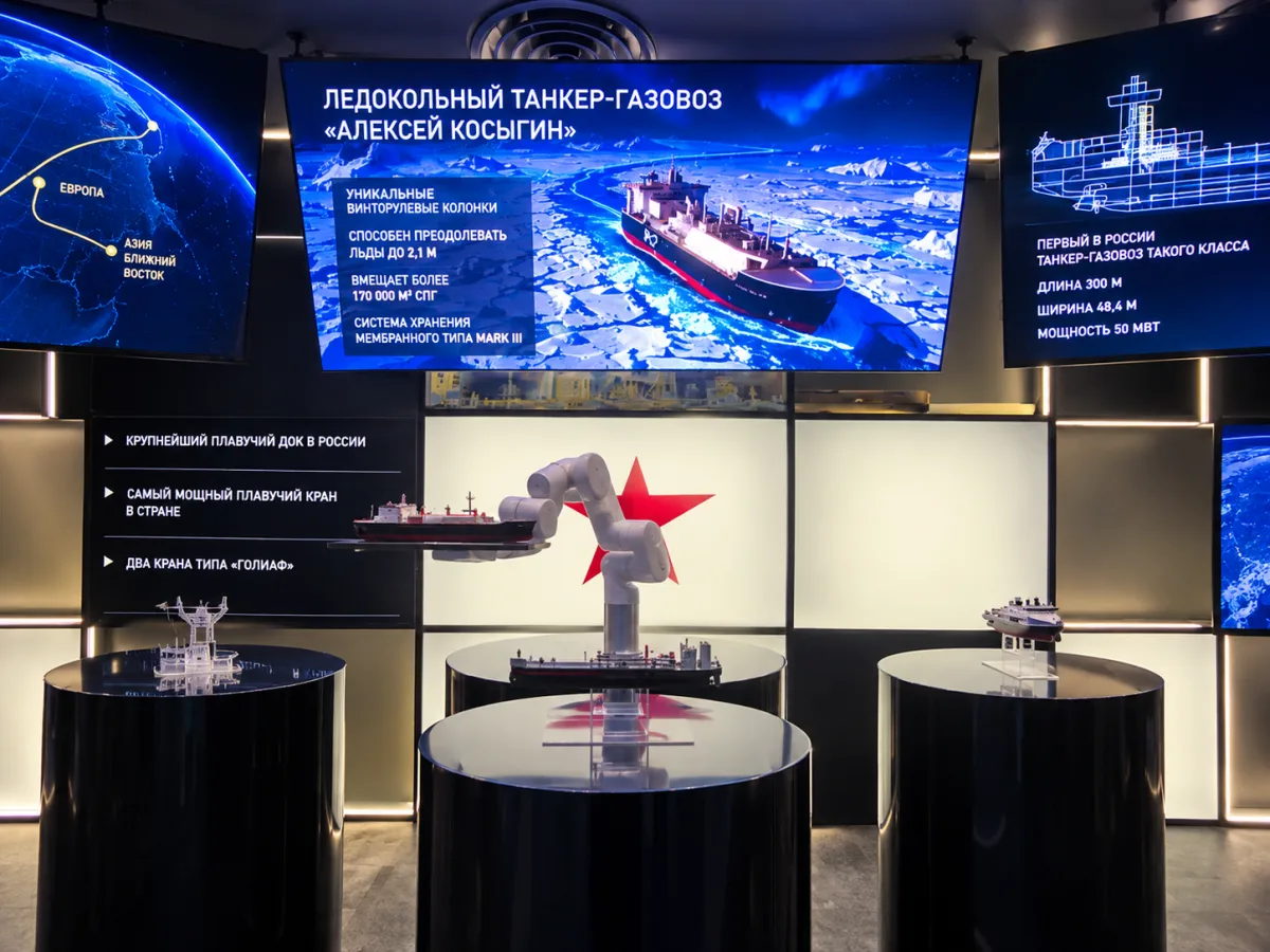 Interactive exhibit with a robotic arm and ship models